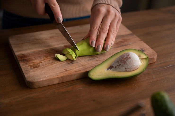 Una persona che taglia un avocado