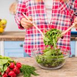 Una persona in cucina gira l'insalata