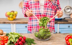 Una persona in cucina gira l'insalata