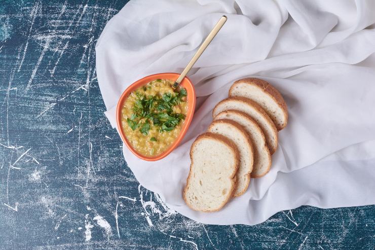 Pesto di melanzane in una ciotola accanto a del pane affettato