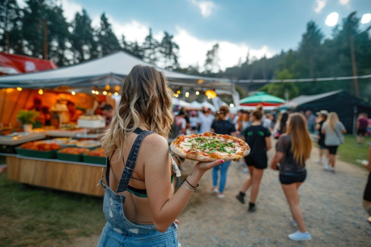 Una ragazza con una pizza a una sagra estiva
