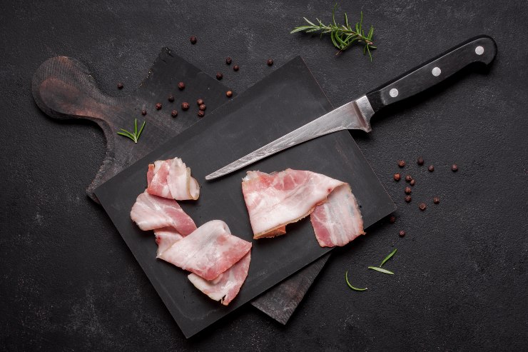 Bacon crudo a fette su un tagliere