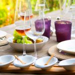 Tavola apparecchiata con bicchieri di vino e piatti