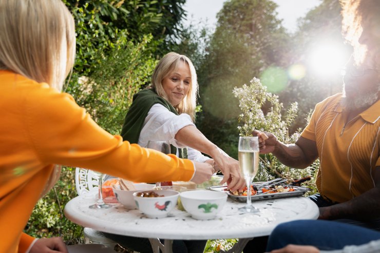 Tre persone che mangiano a tavola insieme