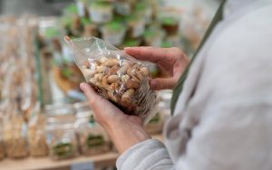Una persona esamina una confezione di frutta secca al supermercato