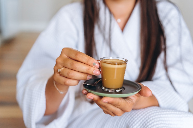 Una donna tiene in mano una tazzina di caffè