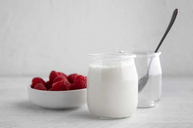 Barattoli di Kefir e Yogurt accanto a dei lamponi